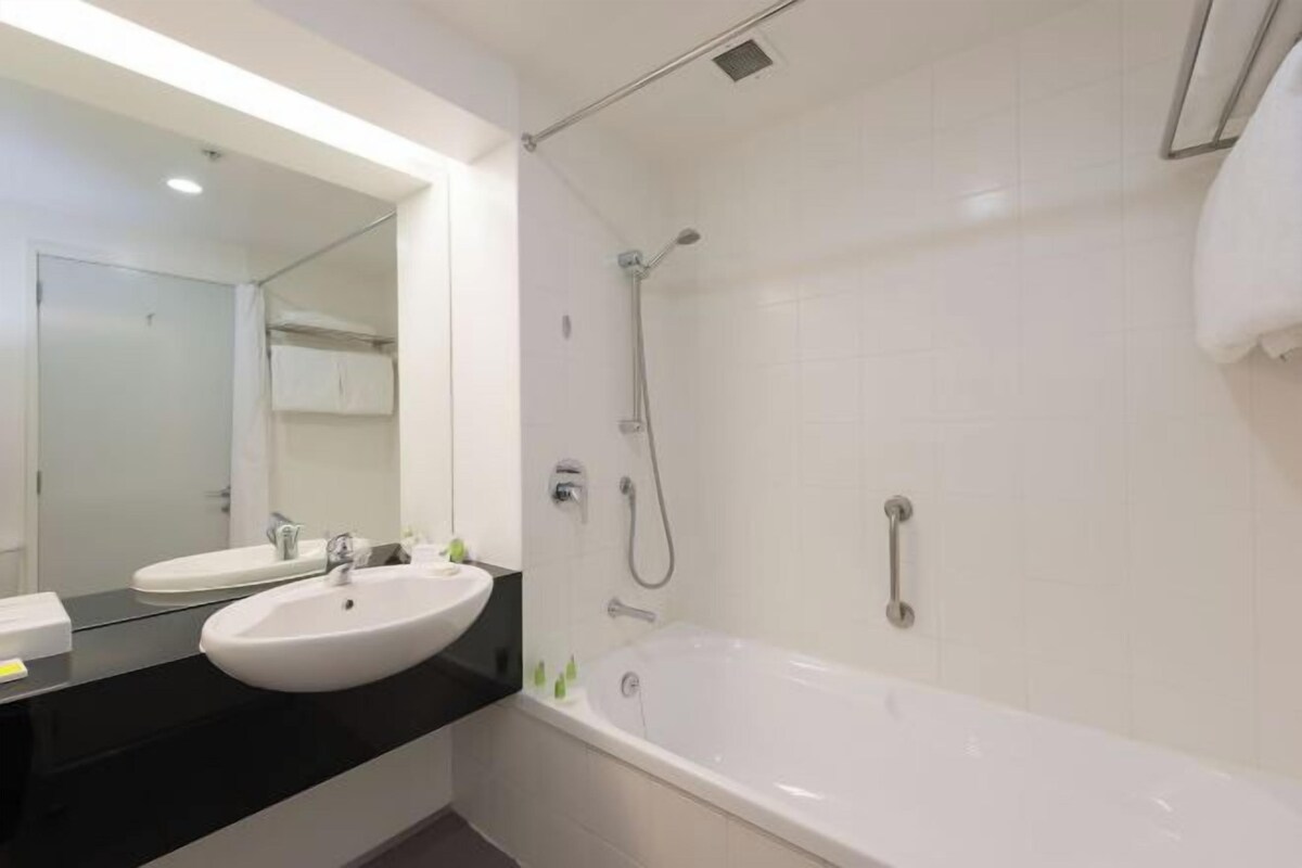 Un baño moderno con un lavabo blanco, una bañera y una ducha.