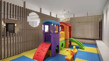 Children can play safely in this enclosed play area featuring a colorful play structure with a slide and climbing elements.