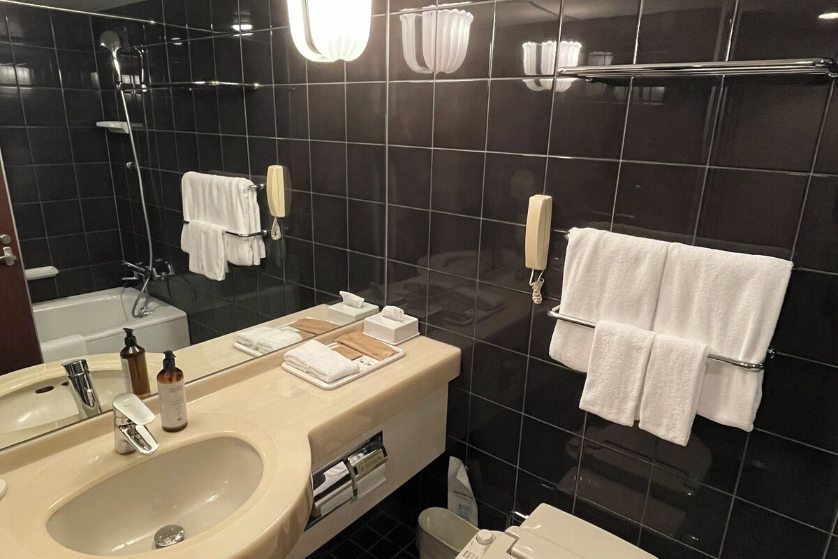 Um banheiro moderno com uma pia grande, espelho e vaso sanitário.