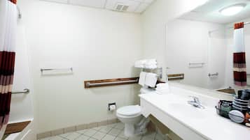 A hotel bathroom with a toilet, sink, and shower area.
