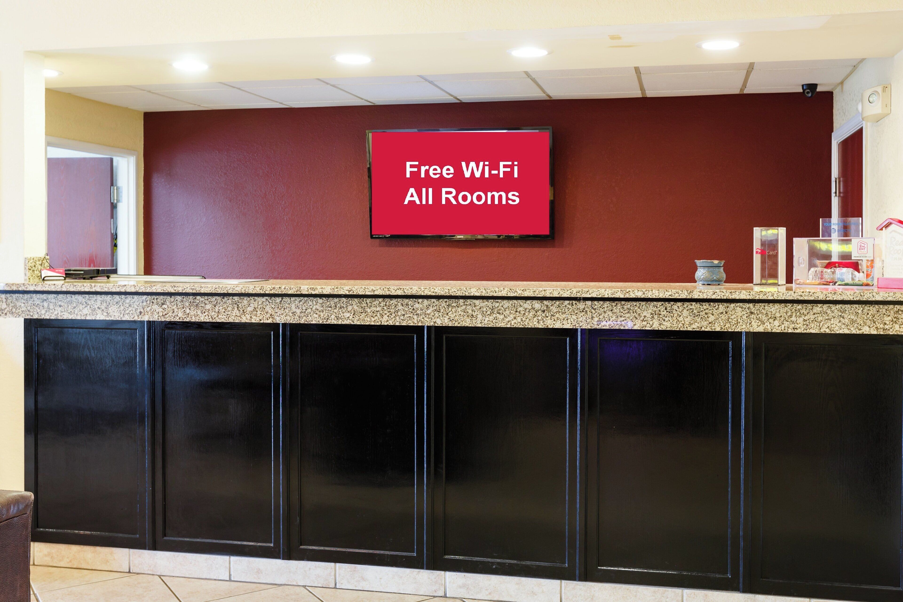Una recepción con un cartel que indica Wi-Fi gratuito en todas las habitaciones.