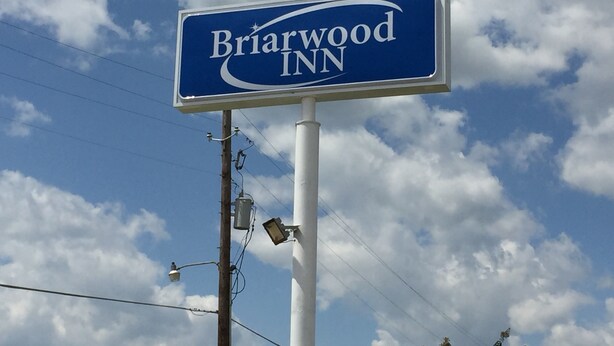 A Biarwood Inn sign against a partly cloudy sky.