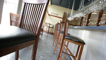 Interior de un restaurante con sillas de madera y una zona de bar.