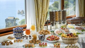 Una mesa de buffet con diversas opciones de comida y vista al mar.