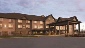 A Country Inn & Suites hotel with a covered entrance, multiple floors, and a parking lot. - Country Inn & Suites by Radisson, Billings, MT (Billings)