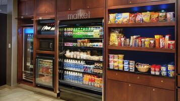 Un supermercado con secciones refrigeradas y estantes repletos de aperitivos y bebidas.