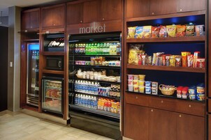 Un supermercado con secciones refrigeradas y estantes repletos de aperitivos y bebidas.