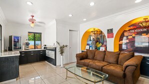 Una cocina moderna con gabinetes negros, una mesa de centro de vidrio y un sofá de cuero marrón.