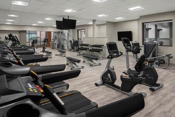 A gym with treadmills, elliptical machines, and weight benches. - Pittsburgh Marriott North (Cranberry Township)
