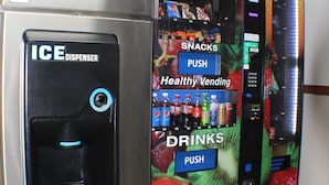 Un distributeur automatique équipé d’un compartiment à glaçons et d’un autre pour les collations et les boissons.