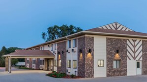 A multi-story hotel with a brick facade, large windows, and a covered entrance. - Super 8 by Wyndham Madison (Madison)