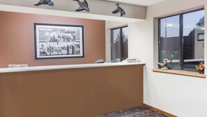 A reception area with a framed welcome sign, a counter, and decorative ducks on the ceiling. - Super 8 by Wyndham Madison (Madison)