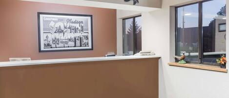 A reception area with a framed welcome sign, a counter, and decorative ducks on the ceiling.