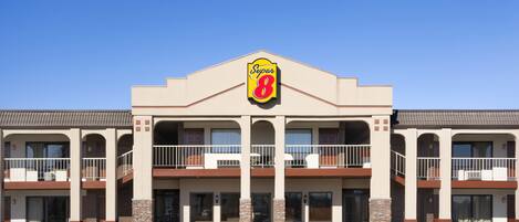 A Super 8 hotel with a central entrance, two-story balconies, and a parking lot in front.