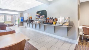 A breakfast bar with a variety of food and drink options, seating area with chairs, and a view of the outside. - Super 8 by Wyndham Wytheville (Wytheville)