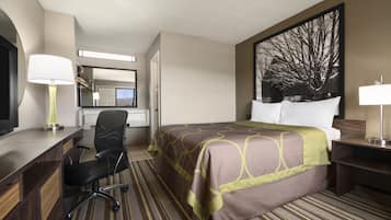 A hotel room with a bed, desk, chair, and a large window.