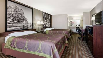 A hotel room with two beds, a desk, a chair, a television, and artwork on the walls.