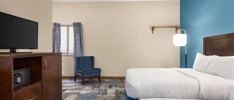 Une chambre d’hôtel avec un lit, une télévision, une chaise et un bureau.