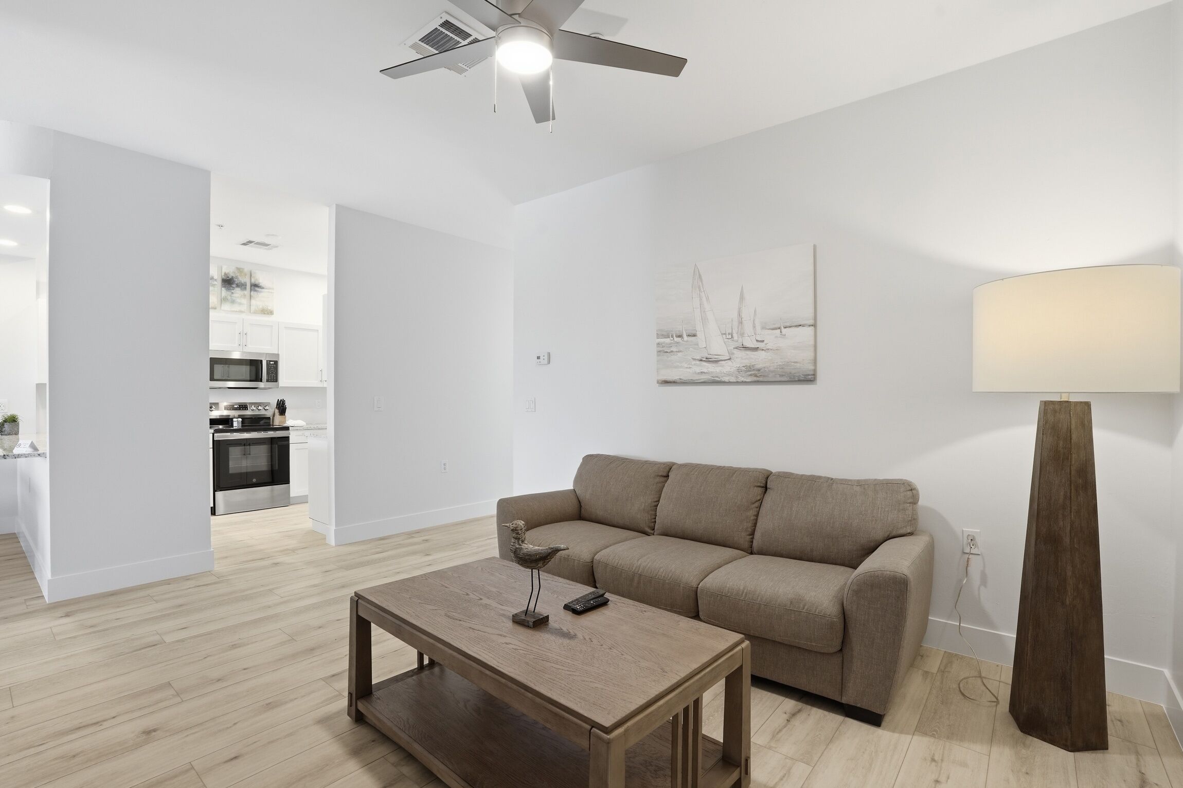 Ein modernes Wohnzimmer mit einer Couch, einem Couchtisch und Kunstwerken an der Wand.