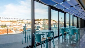 Une terrasse sur le toit, aménagée avec des tables et des chaises, d’où l’on peut admirer la vue sur la ville.