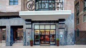 Un immeuble doté d’une enseigne lumineuse indiquant « Aparthotel VIP Eden » et d’une grande entrée en verre.