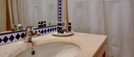 A bathroom with a sink, mirror, and toiletries.
