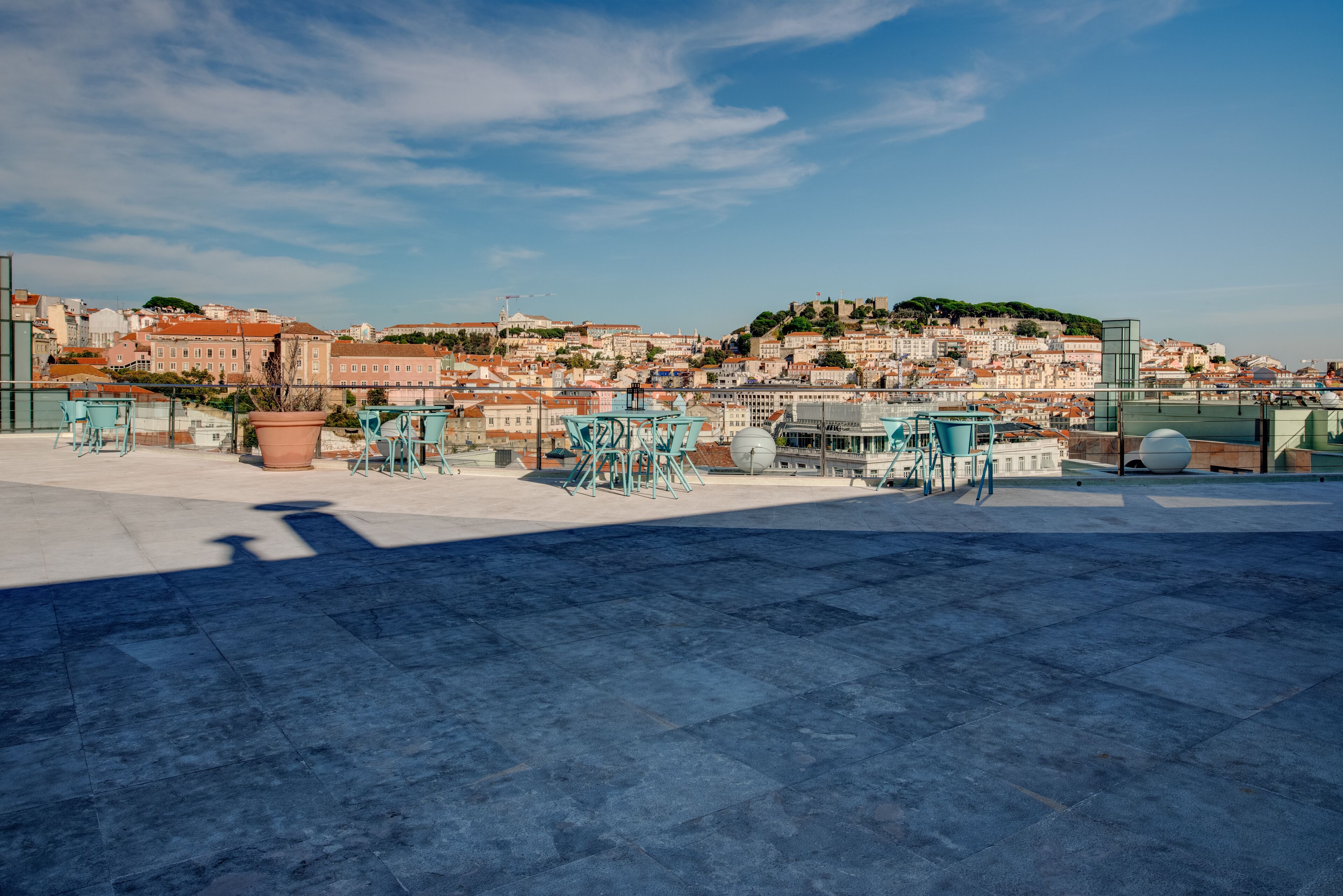 A rooftop terrace with outdoor seating and a view of a cityscape.