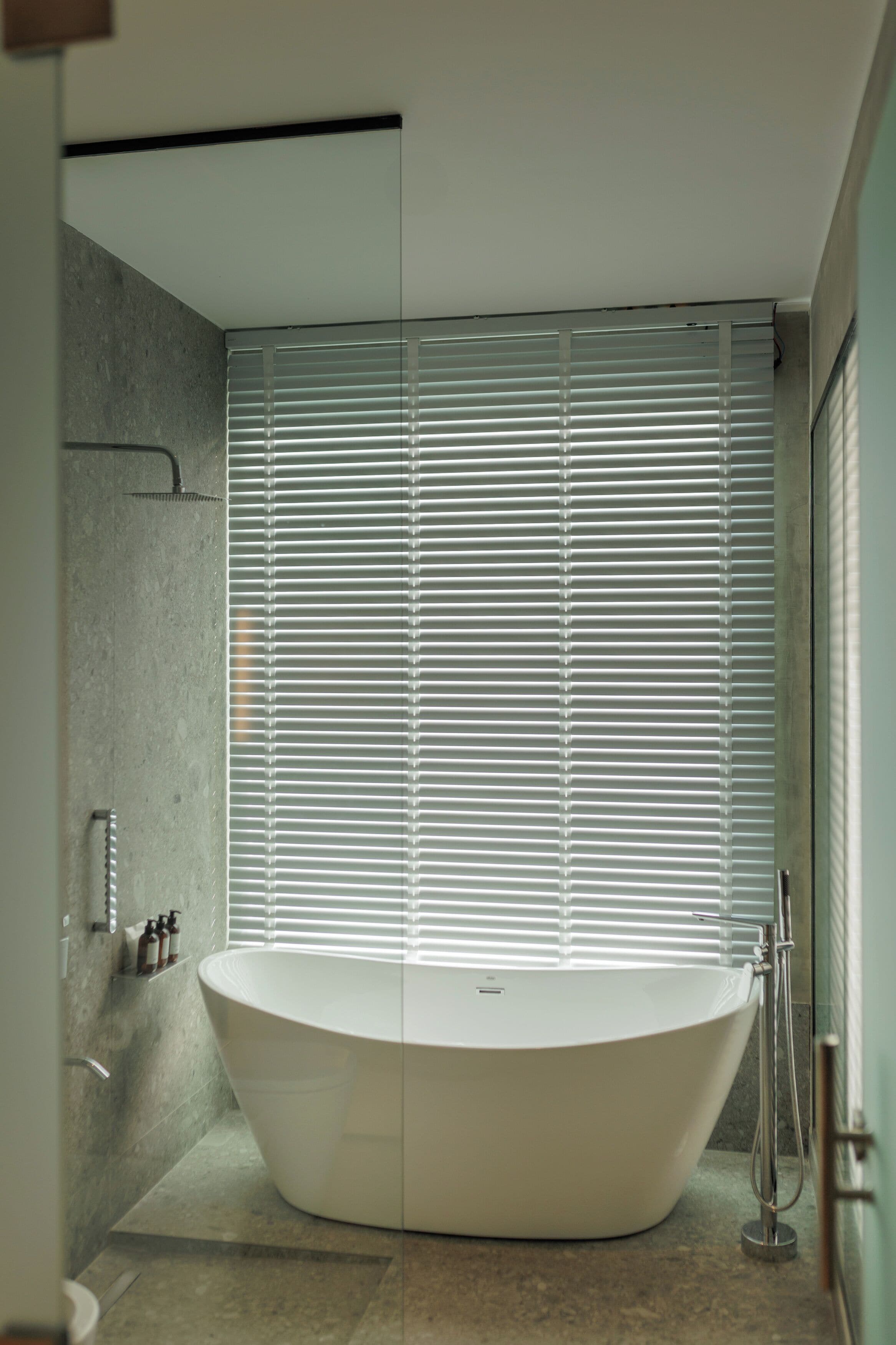 Een moderne badkamer met een vrijstaand bad, een douchegedeelte en een glazen douchedeur.