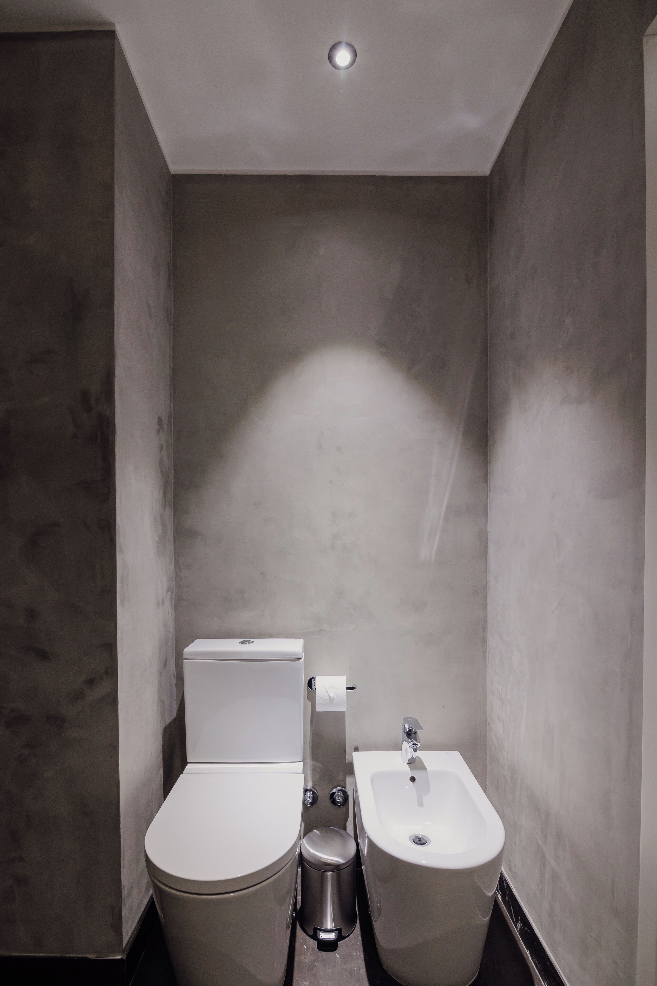 A modern bathroom with a toilet, bidet, and sink.