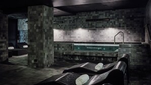 Un área de spa con camillas de masaje, una recepción y una pared con azulejos.