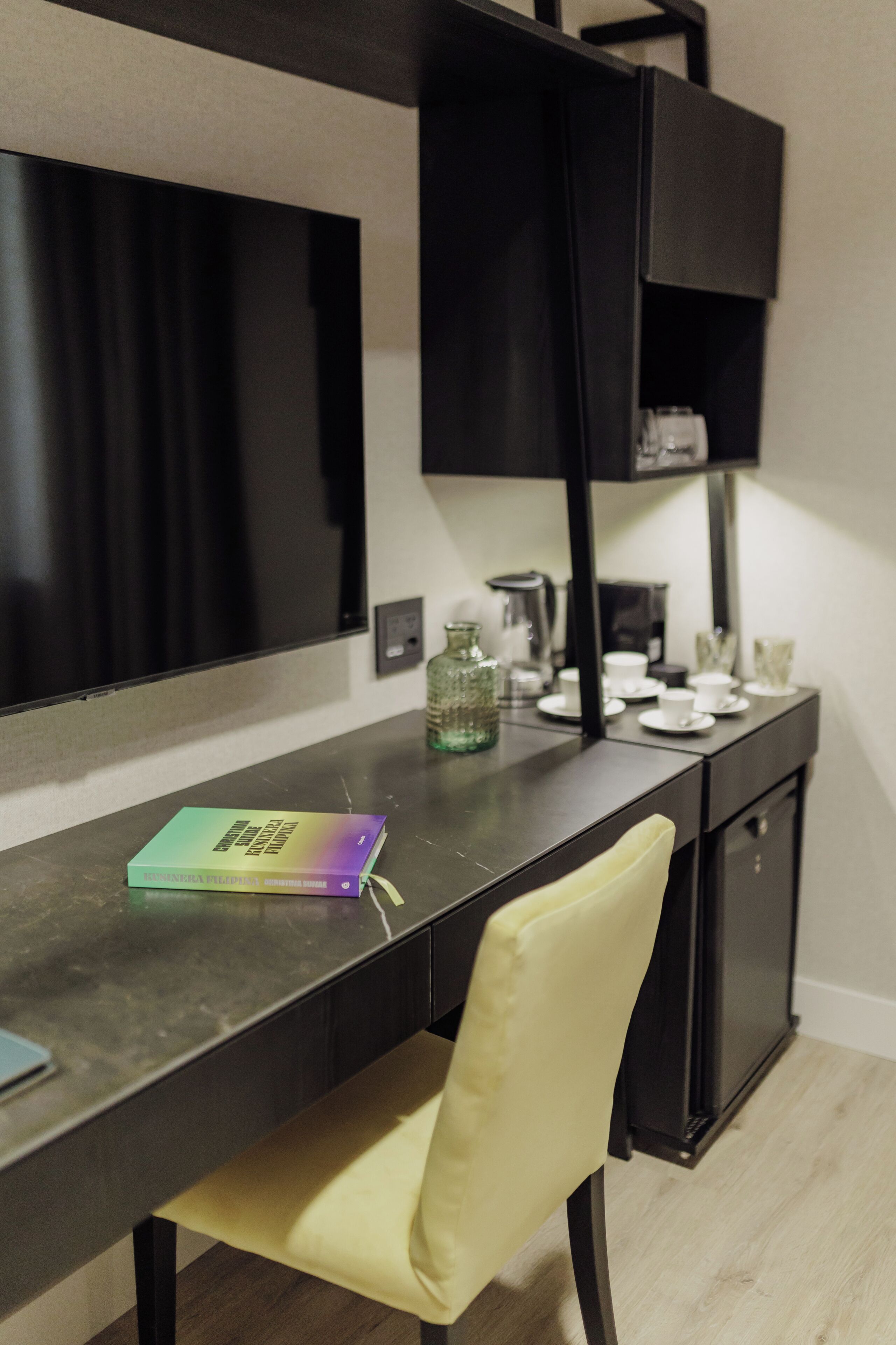 Una habitación moderna con escritorio, silla y televisor de pantalla plana en la pared.