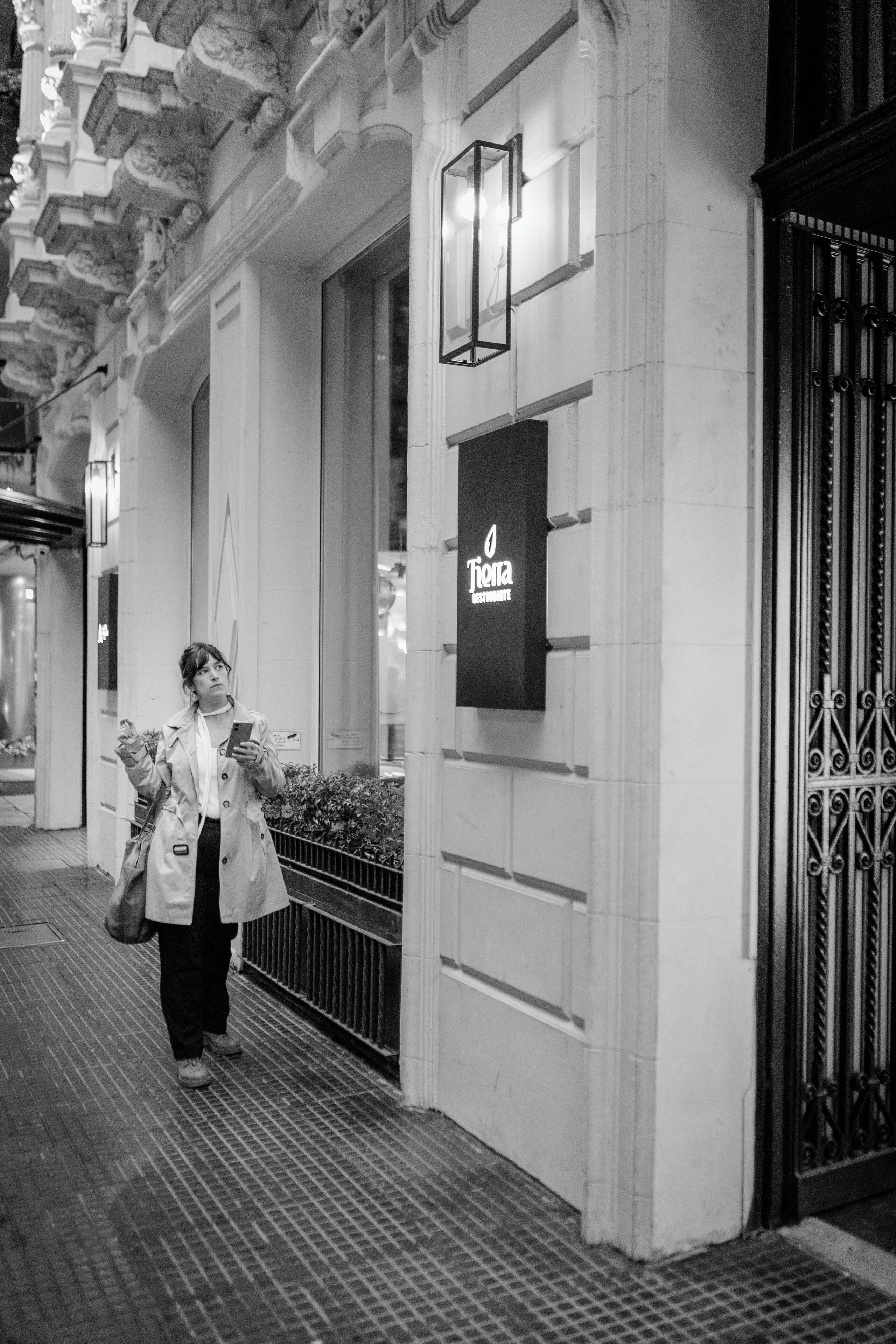 Une personne marchant sur un trottoir, à côté d’un bâtiment sur lequel on peut lire l’inscription « Tierra Restaurante ».