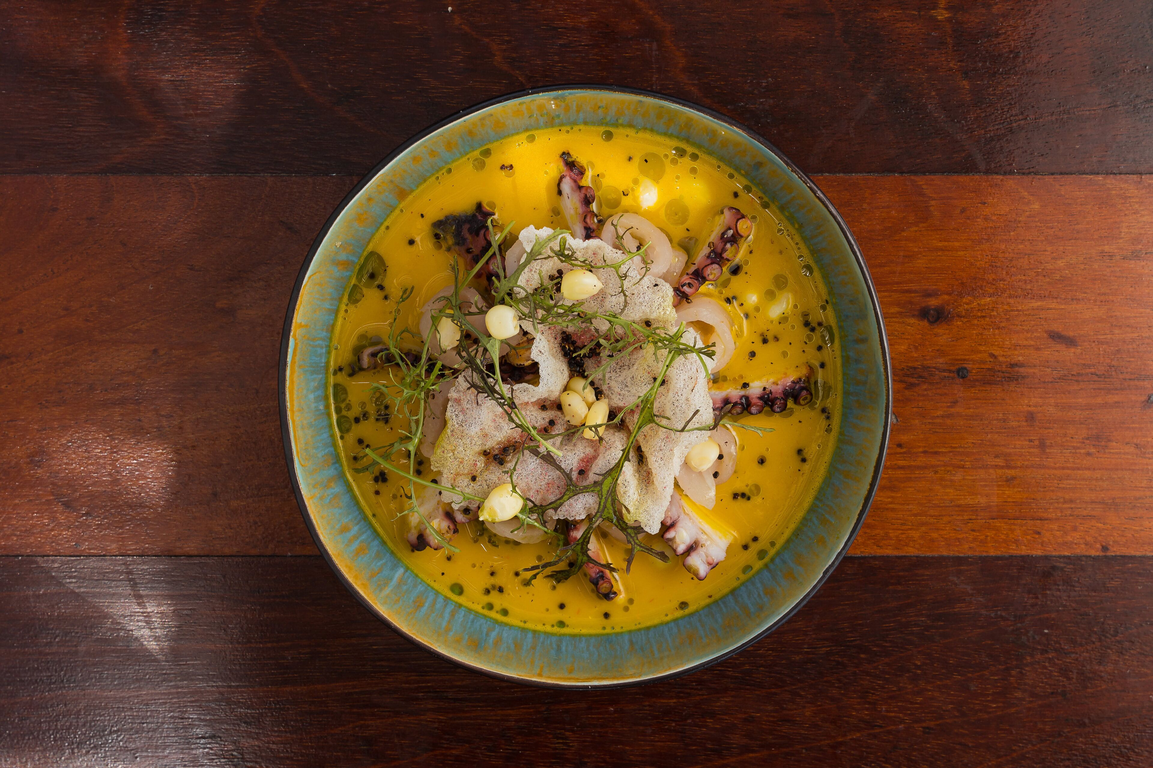 Un plato de pulpo sobre una mesa de madera.