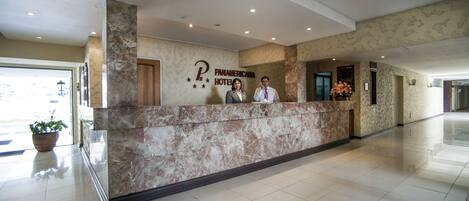 Ein Hotelrezeptionstresen mit einer Marmorplatte und einem Schild mit der Aufschrift 'Panamericana Hotel'.