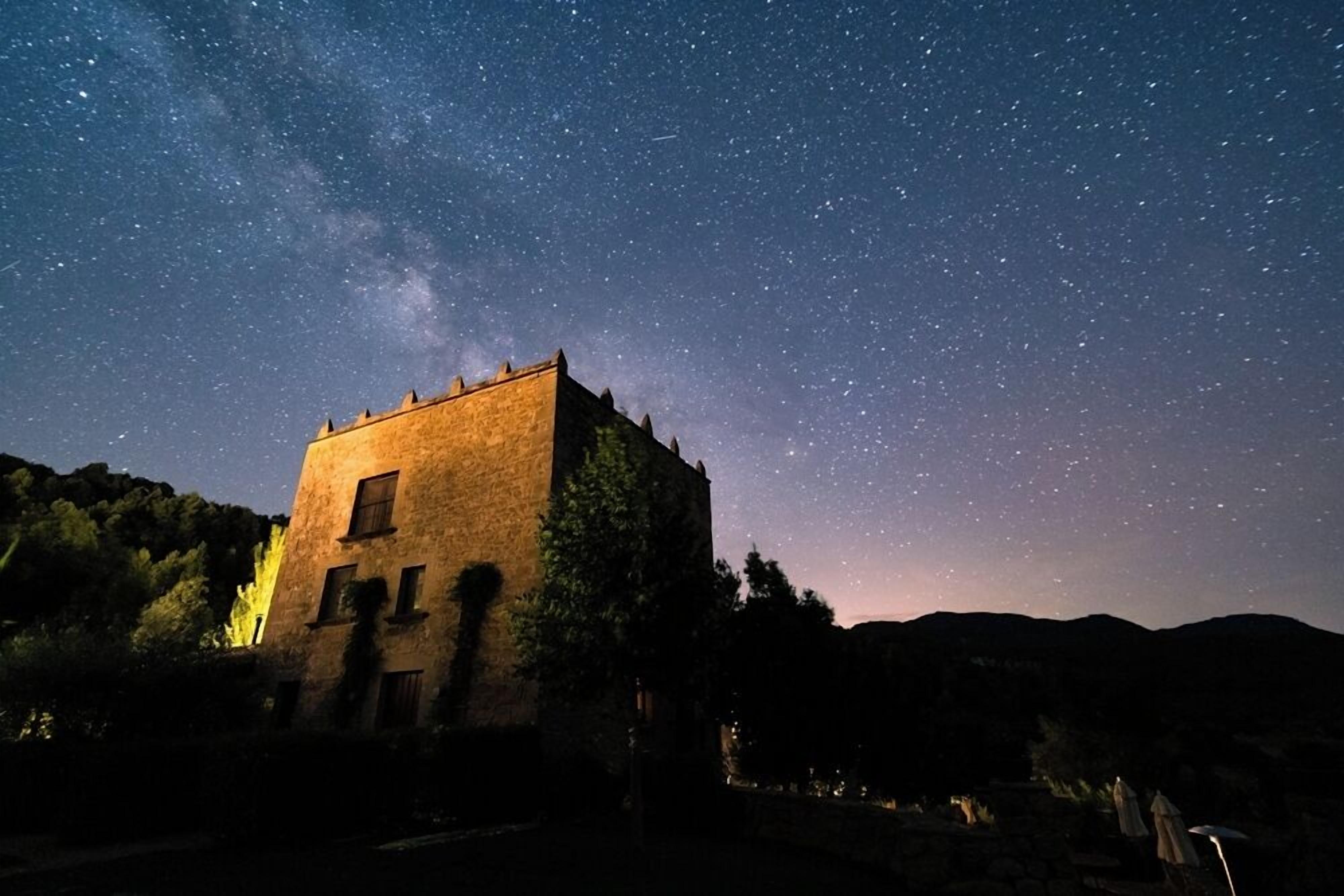 A stone building with a starry night sky above.