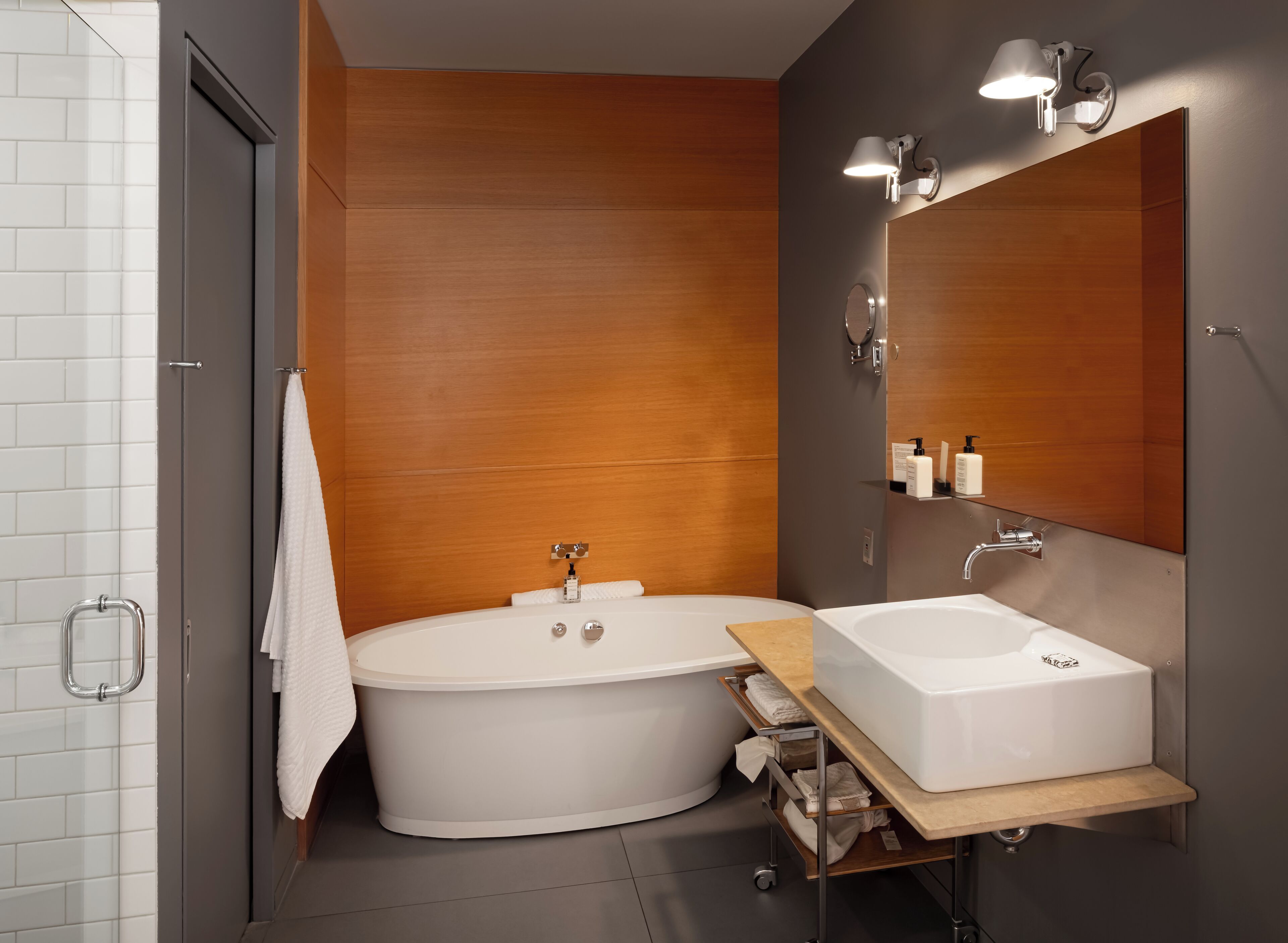 Une salle de bain moderne avec une baignoire sur pieds, un meuble-lavabo et un grand miroir.