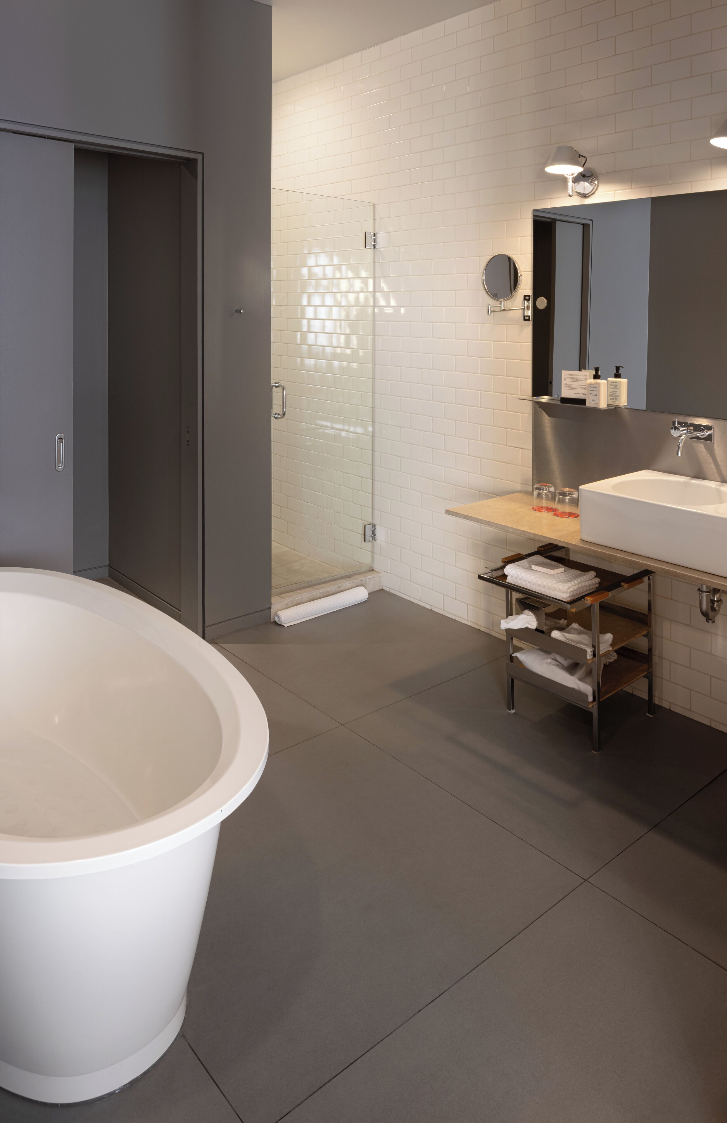 A modern bathroom with a freestanding bathtub, a glass-enclosed shower, and a vanity with a mirror and sink.