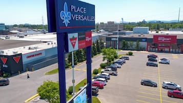 A parking lot with multiple cars, a sign for Place Versailles, and a building with a red sign labeled "bureau en gros".