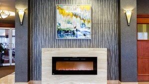 Un vestíbulo moderno con chimenea, paredes con textura e iluminación empotrada.