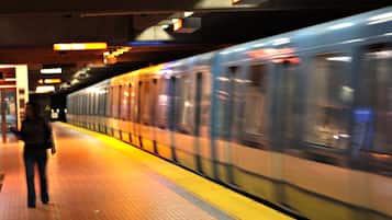 Un andén de metro con un tren en movimiento.