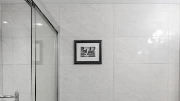 A modern bathroom with a glass shower enclosure, a toilet, and a vanity with a sink.