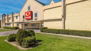 Un hotel con un llamativo letrero de EconoLodge, estilo arquitectónico moderno y jardines bien cuidados.