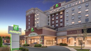 A Holiday Inn hotel with a city center entrance, multiple floors, and a well-lit facade.