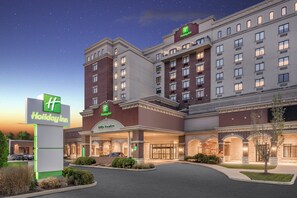 A Holiday Inn hotel with a city center entrance, multiple floors, and a well-lit facade.