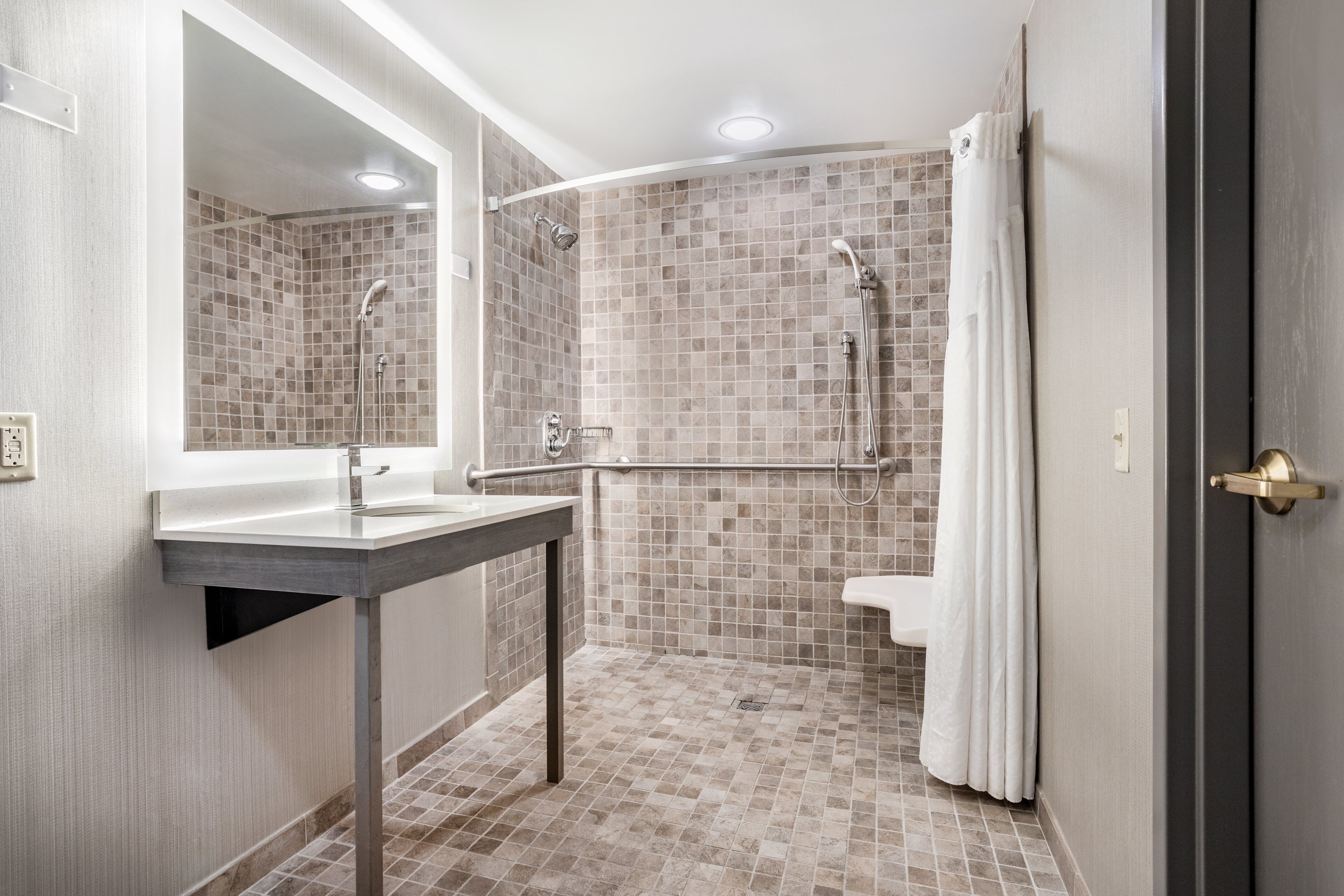A modern bathroom with a shower, a sink, and a toilet.