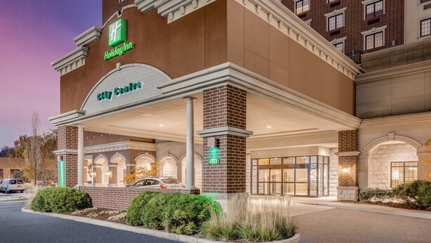 A Holiday Inn Express hotel with a brick facade, a covered entrance, and a parking lot. - Holiday Inn Lafayette-City Centre by IHG (Lafayette)