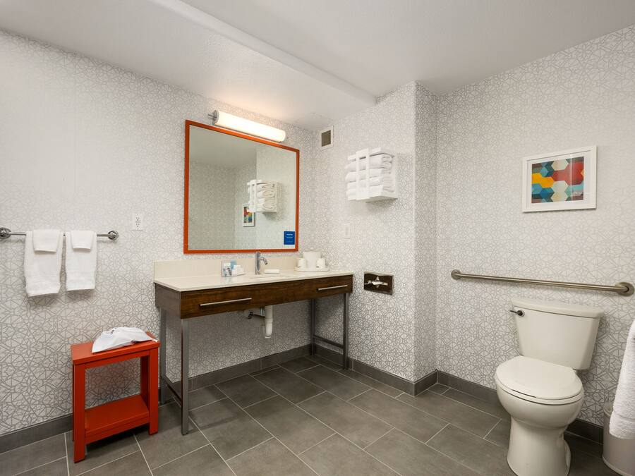 Un bagno moderno con WC, lavabo e specchio.