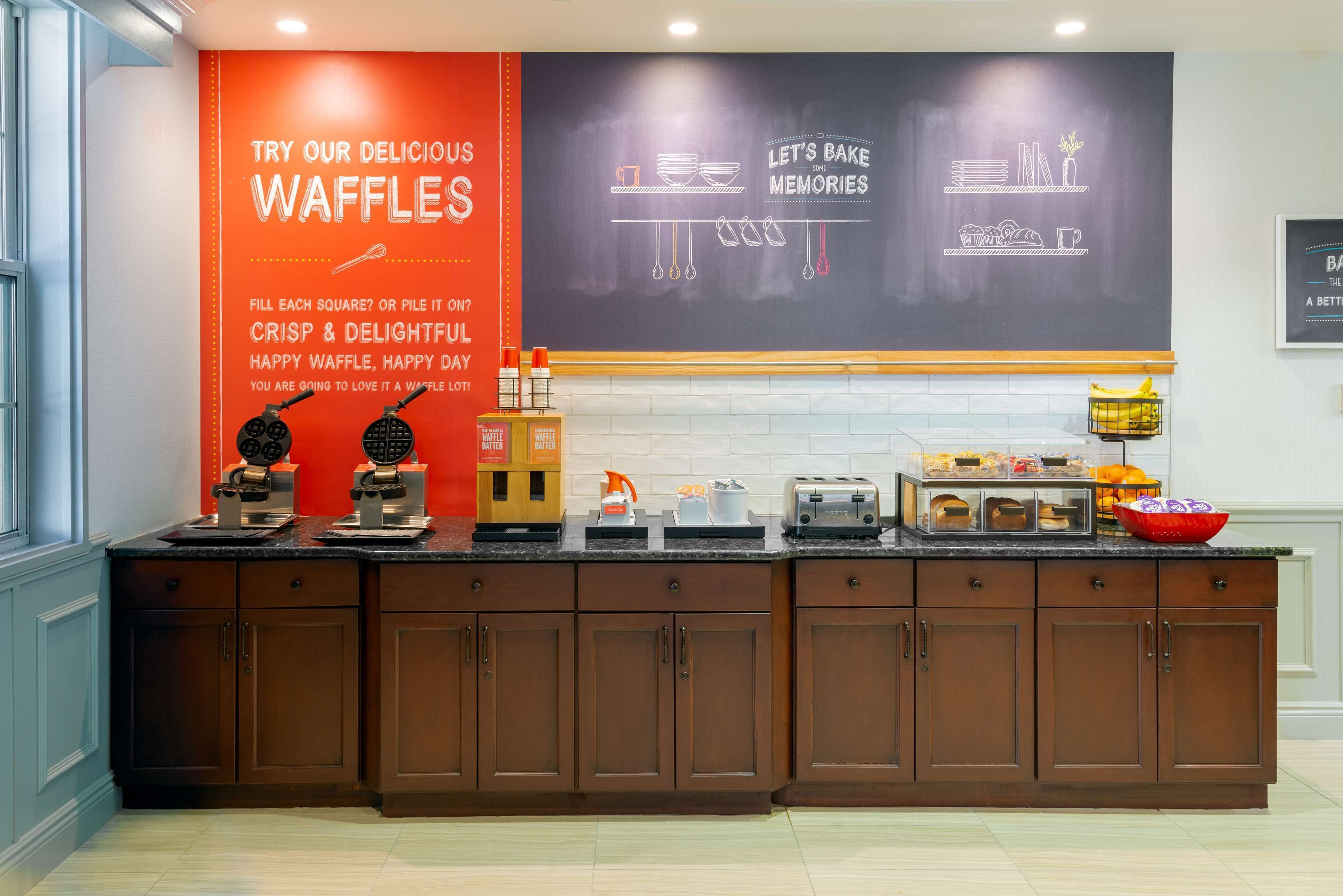 A kitchen counter with waffle makers, a coffee machine, and a toaster.