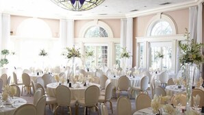 A banquet hall with round tables, white chairs, and floral centerpieces. - Vizcaya (Sacramento)