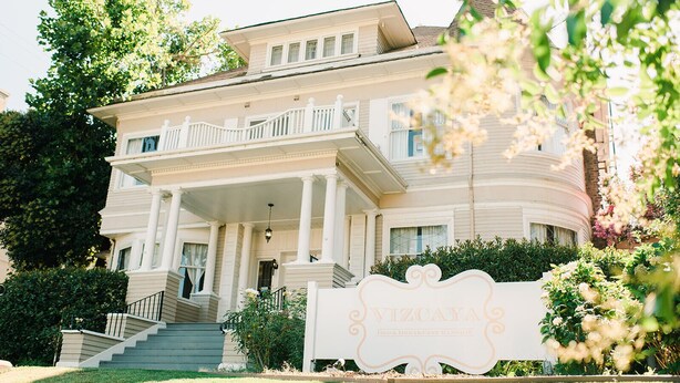 A large, two-story building with a prominent porch and a sign that reads "VIZCAYA BED & BREAKFAST MANSIONS". - Vizcaya (Sacramento)
